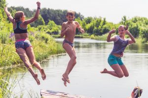 Drei Kinder, die in den See springen