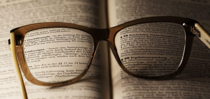 Eine Brille liegt auf einem aufgeschlagenen Gesetzbuch