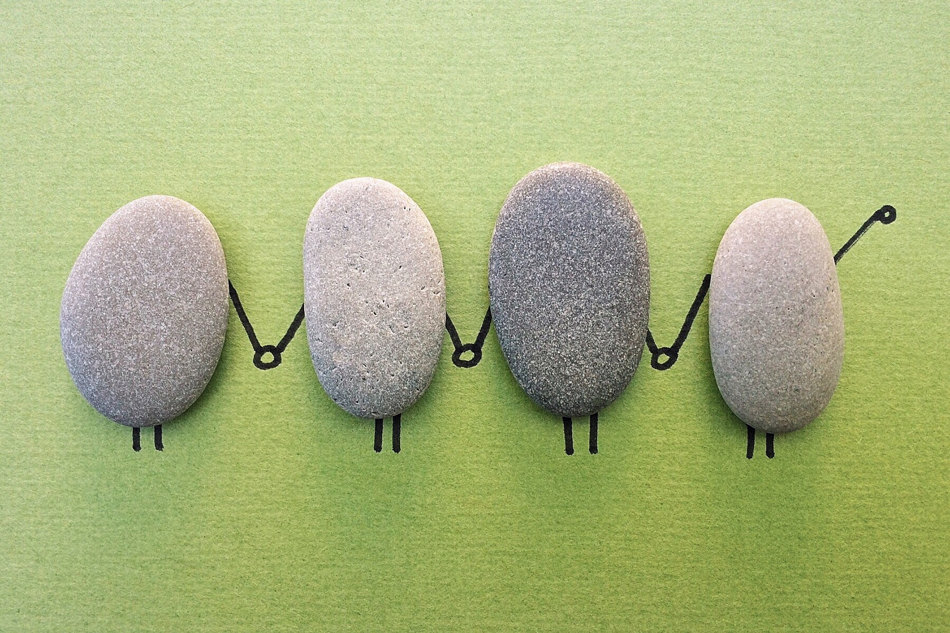 Vier Steinmännchen halten sich an den Händen.