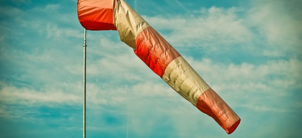 Windsocke weht im Wind vor blauem Himmel