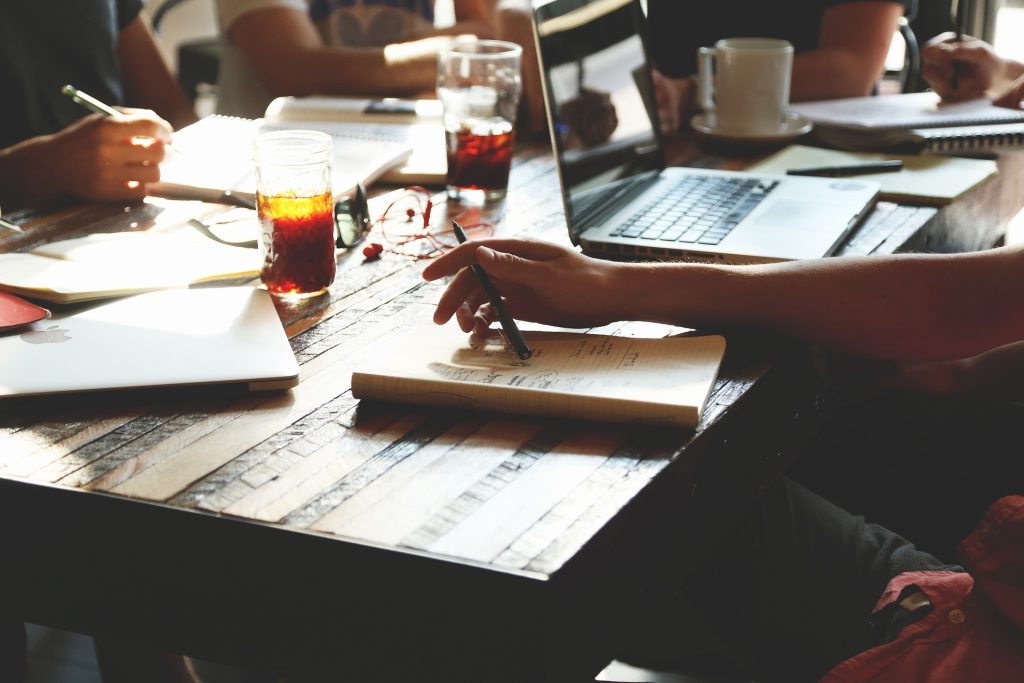 Menschen sitzen gemeinsam am Tisch und arbeiten