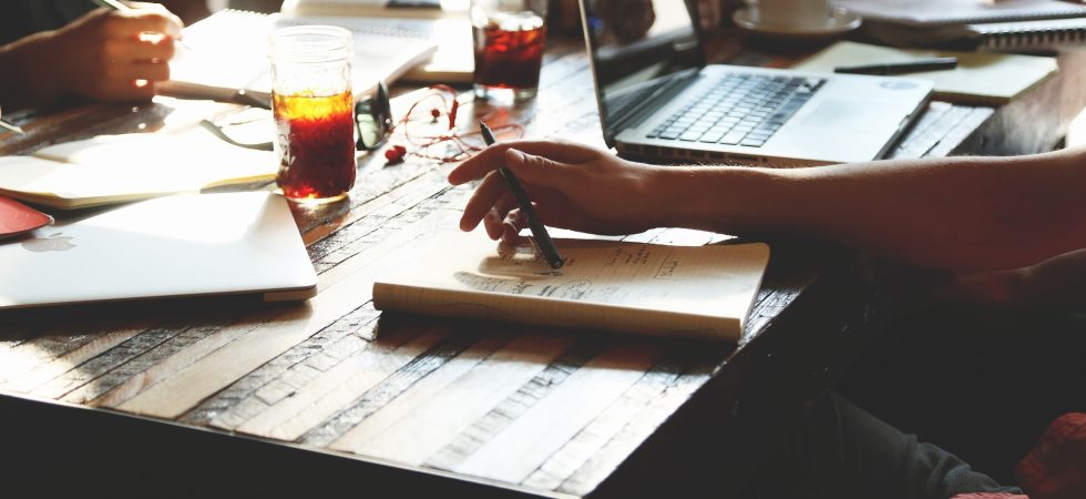 Menschen sitzen gemeinsam am Tisch und arbeiten